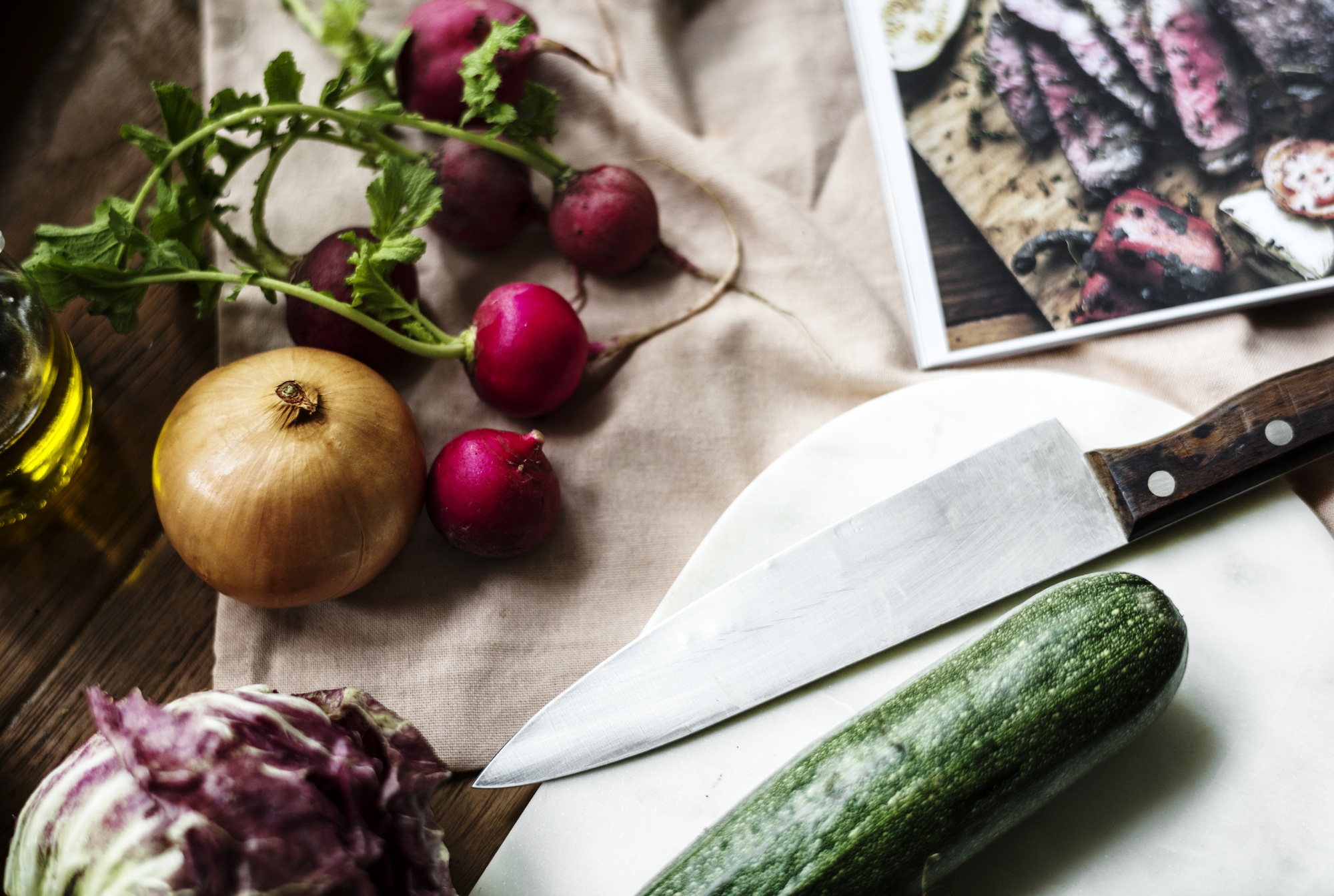 Workshop table with seasonal vegetables and knives laid out