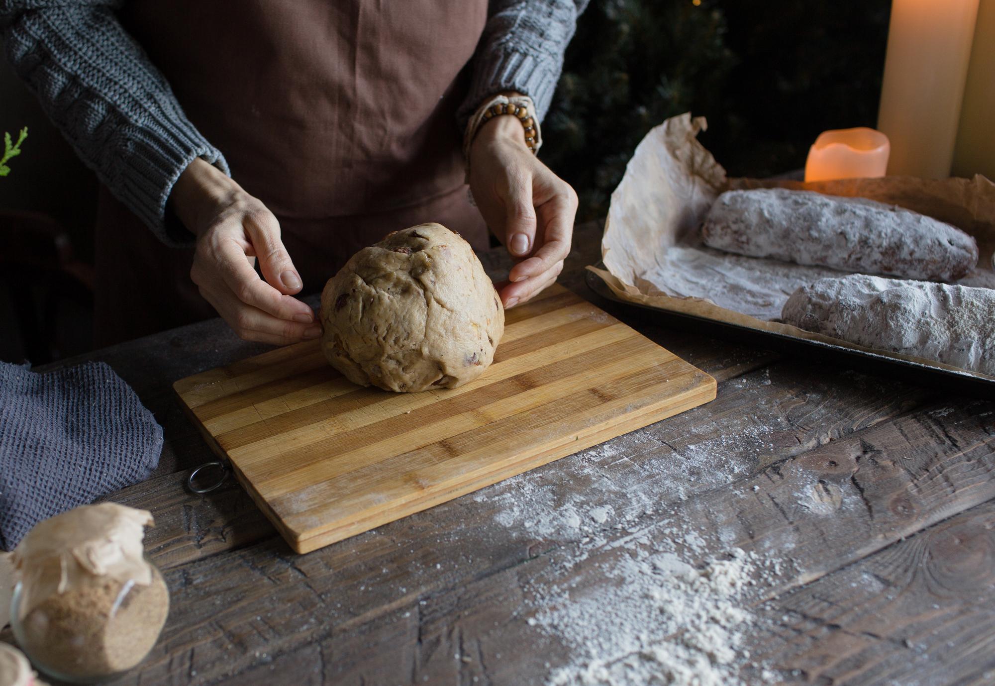 Close-up of hands shaping dough on a floured board